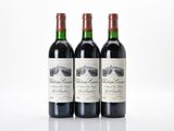 three bottles of red wine sitting on top of a white table