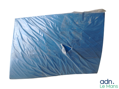 une feuille bleue percée d'un trou sur fond blanc