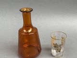 a glass and a bottle sitting next to each other on a table