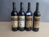 four bottles of wine are lined up on a table