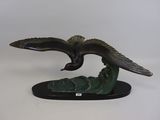 statue représentant un aigle planant au-dessus d'une vague sur fond blanc
