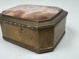 a gold box with a marble top sitting on a white surface