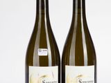 deux bouteilles de vin posées l'une à côté de l'autre sur une surface blanche