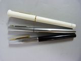 trois stylos sont alignés les uns au-dessus des autres sur une table