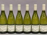 six bouteilles de vin sont alignées sur une table