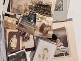 a pile of old photographs on a table next to a pair of scissors and a pair of scissors