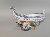 a small boat shaped dish with a fish on it