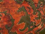 a close up of a rusted metal plate with designs on it