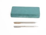 deux stylos et un étui à stylos posés sur une surface blanche