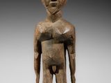 une statue en bois représentant un homme coiffé d'un casque