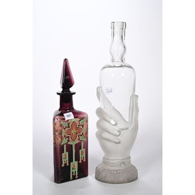 une bouteille en verre et une statue représentant une main, placées l'une à côté de l'autre