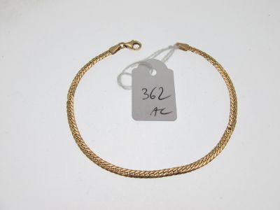 gros plan d'un bracelet en or portant une étiquette de prix
