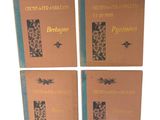 quatre livres sont alignés sur une surface blanche