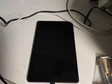 a tablet computer sitting on a desk with a charger