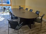 une grande table entourée de chaises dans une pièce