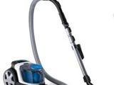 un aspirateur posé par terre à côté d'un bidon