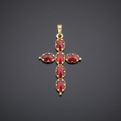 a gold cross with red stones on a black background