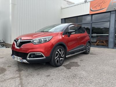 une voiture rouge garée devant un immeuble, sur un parking