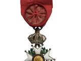 un gros plan d'une médaille sur fond blanc, avec un ruban rouge