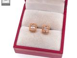a pair of earrings in a box with a ring inside of it