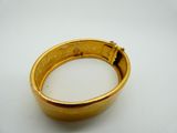 a close up of a gold ring on a white surface