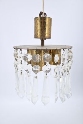 lustre en laiton et cristal, avec des pendants en verre et des ferrures en laiton
