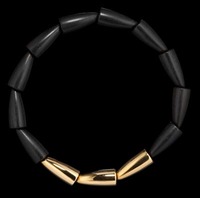 un gros plan d'un bracelet noir et doré sur fond noir