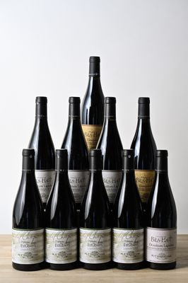six bouteilles de vin sont alignées sur une table en bois