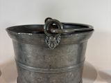 a small metal container with a handle on a table