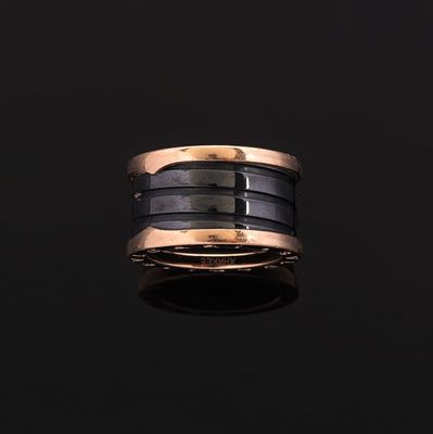 un gros plan d'une bague noire et dorée posée sur une surface noire