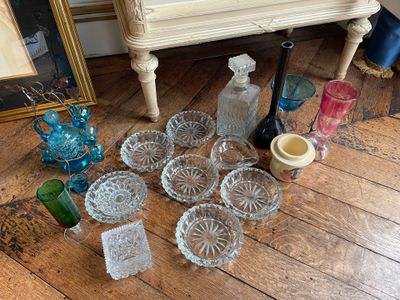 a lot of glass items on the floor next to a dresser