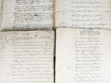 several old papers are stacked on top of each other on a table