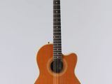 une guitare acoustique orange accrochée à un mur blanc