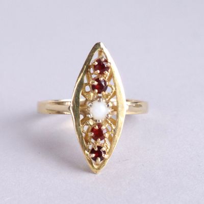 une image représentant une bague en or sertie d'une pierre rouge et blanche