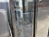 several stainless steel refrigerators are lined up in a warehouse