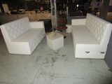 two white couches and a coffee table in the middle of a room
