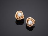 a pair of gold and pearl earrings on a black surface