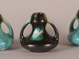 three black and green vases sitting next to each other on a table