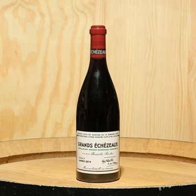 a bottle of wine sitting on top of a barrel