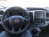 a man sitting in the driver ' s seat of a car