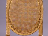 a close up of a chair with a wicker back and seat