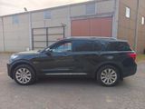 une photo d'un SUV noir garé devant un immeuble