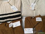 three sweaters and a hat are sitting on a table