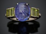 un gros plan d'une bague sertie d'une tanzanite et d'une tourmaline verte