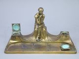 a bronze statue of a man holding a clock on a stand