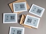 plusieurs feuilles de papier sur lesquelles figure un code QR, posées sur une table