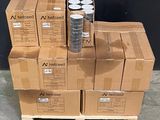 des cartons empilés les uns sur les autres sur une palette devant un mur noir