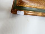 un vase marron et vert posé sur une table blanche