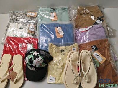 Plusieurs paires de tongs, un chapeau et d'autres vêtements sont posés sur une table