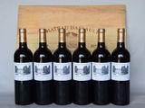 six bouteilles de vin rouge sont alignées devant une caisse en bois
